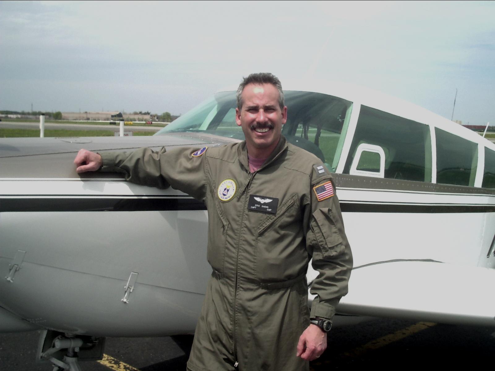 Eric Sachs beside an aircraft in a Coast Guard Auxiliary flight suit